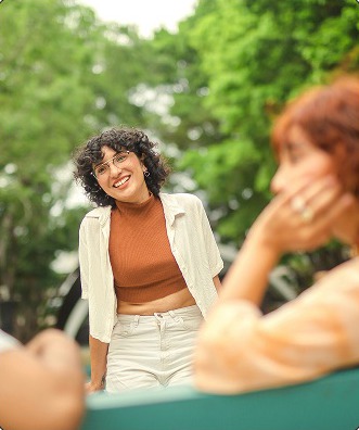 Community members gathered outdoors in a park, smiling and talking together.